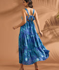 Back view of blue maxi dress featuring open-back detail and self-tie bow