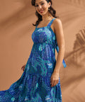 Woman wearing a breezy blue resort dress with square neckline and flowing silhouette