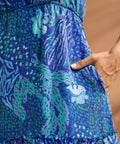 Detail of side pocket and blue abstract print on tiered maxi dress