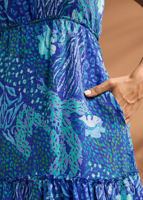 Detail of side pocket and blue abstract print on tiered maxi dress