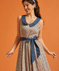 Front view of a cotton fit-and-flare dress featuring a novelty horseshoe print, contrast Peter Pan collar, and removable blue waist sash.