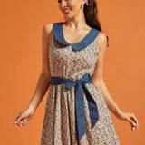 Front view of a cotton fit-and-flare dress featuring a novelty horseshoe print, contrast Peter Pan collar, and removable blue waist sash.