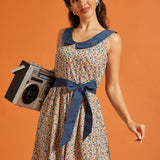 Woman carrying a boombox while wearing a retro fit-and-flare dress with a horseshoe print, oversized Peter Pan collar, and waist tie.