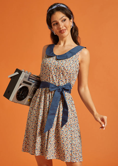 Woman carrying a boombox while wearing a retro fit-and-flare dress with a horseshoe print, oversized Peter Pan collar, and waist tie.