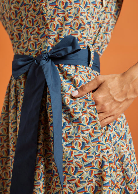 Close-up of the removable blue sash and hidden side pocket on a colorful novelty horseshoe print cotton dress.