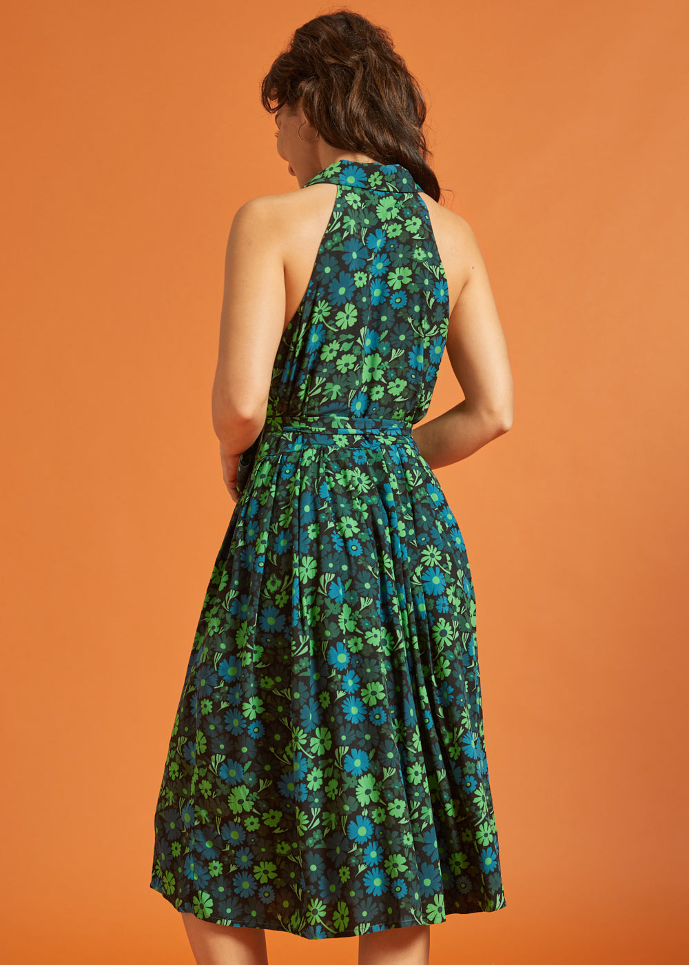 Back view of woman wearing sleeveless green floral midi dress