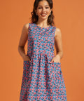 Woman wearing a vintage-inspired sleeveless floral dress with roomy front pockets.