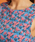 Close-up of the crew neckline and blue floral cotton print on the sleeveless dress.