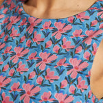 Close-up of the crew neckline and blue floral cotton print on the sleeveless dress.