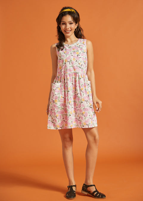 Woman wearing a vintage-inspired pink fruit print mini dress with pockets