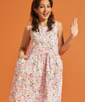 Woman wearing a pink citrus print sleeveless swing dress with oversized pockets