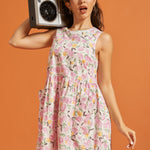 Woman wearing a pink lemon print cotton dress while carrying a retro boombox