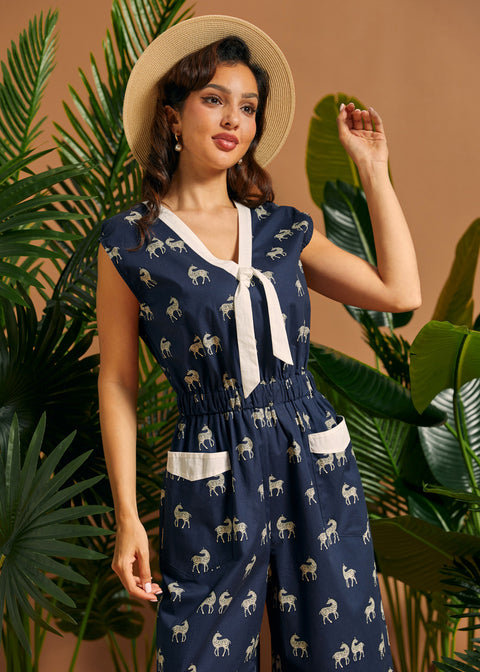 Side view of a navy safari-inspired jumpsuit with zebra print, tie neckline, and elastic waist.