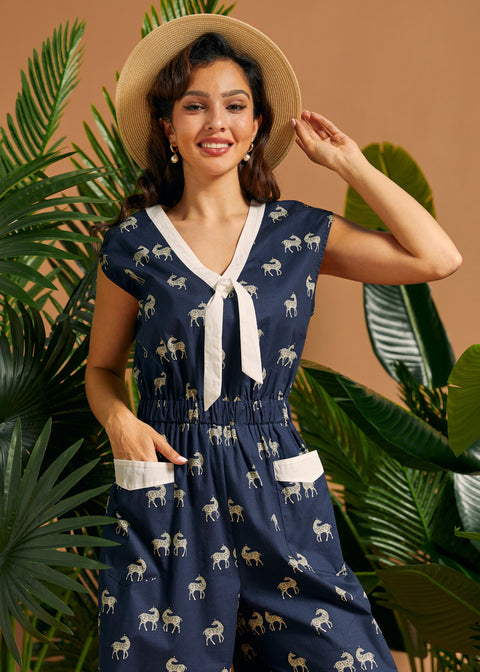 Woman wearing a retro wide-leg zebra print jumpsuit with front patch pockets and cap sleeves.