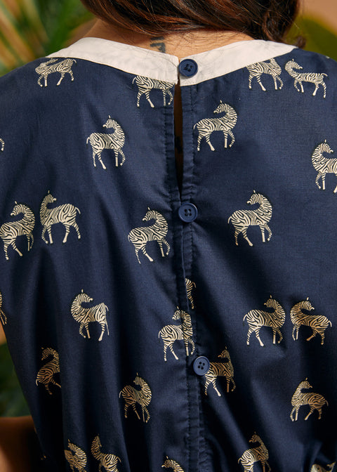 Back detail showing the button closure and zebra print on the navy jumpsuit.