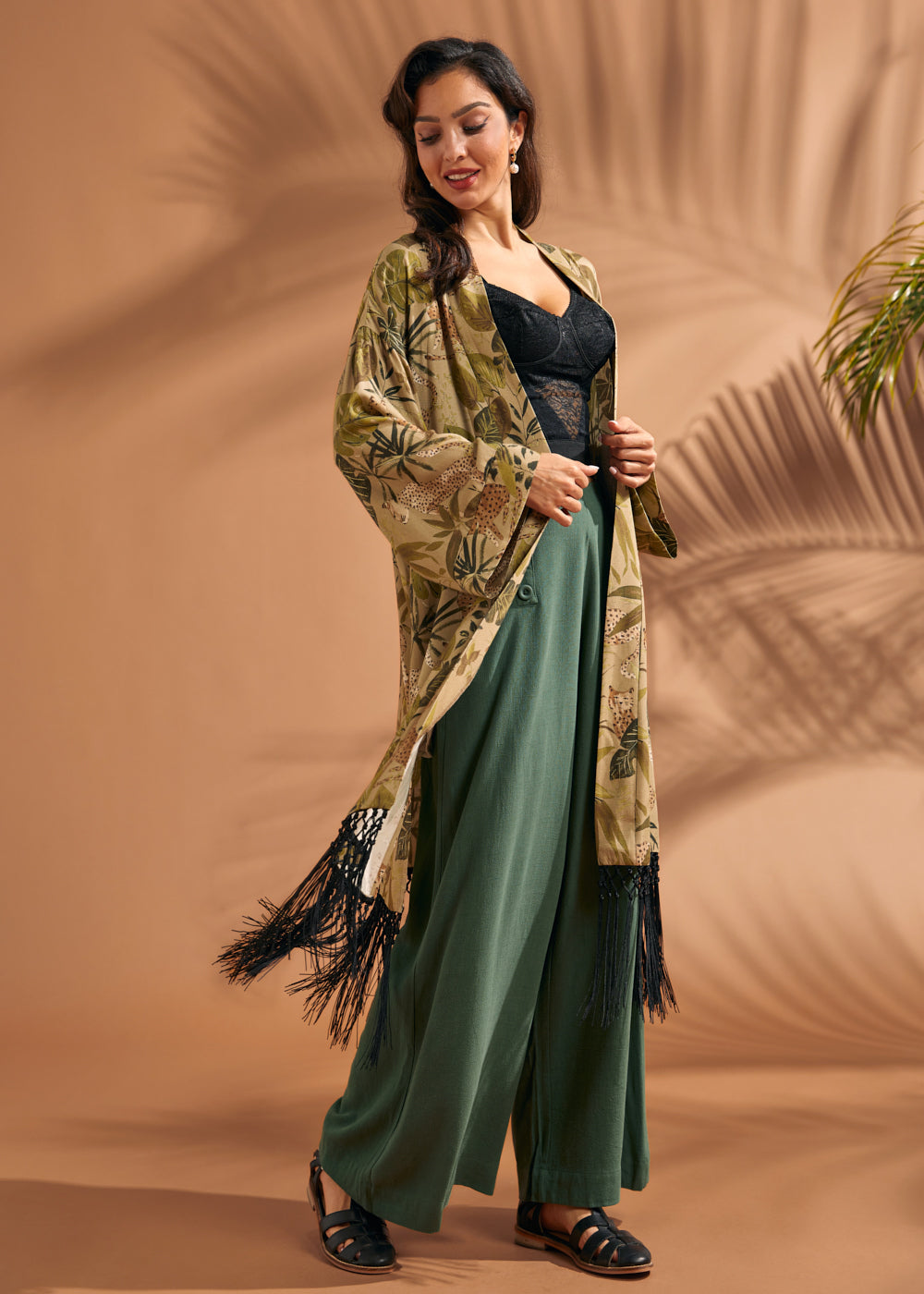 Woman styling tropical print duster with flowing silhouette and black fringe hem.