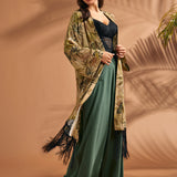 Woman styling tropical print duster with flowing silhouette and black fringe hem.