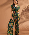 Woman wearing vintage-inspired tropical tiki print wide leg pants with matching top.