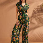 Woman wearing vintage-inspired tropical tiki print wide leg pants with matching top.