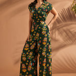 Side angle of woman wearing tropical novelty print wide leg trousers.