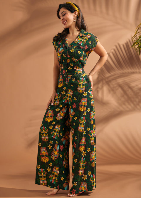 Side angle of woman wearing tropical novelty print wide leg trousers.