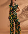 Woman wearing matching tropical tiki print blouse and matching wide leg pants set.