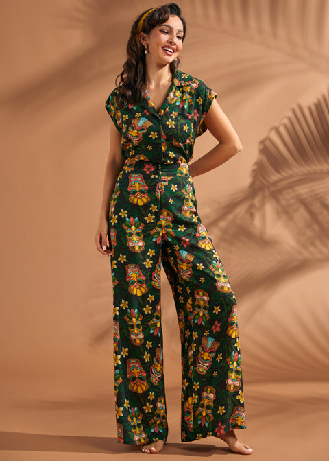 Woman wearing matching tropical tiki print blouse and matching wide leg pants set.