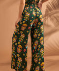 Woman wearing tiki print wide leg pants showing comfortable elastic back waistband.
