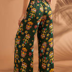 Woman wearing tiki print wide leg pants showing comfortable elastic back waistband.