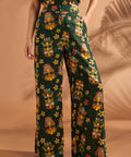 Woman wearing colorful tiki mask print pants with relaxed wide leg silhouette.