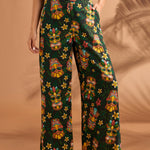Woman wearing colorful tiki mask print pants with relaxed wide leg silhouette.