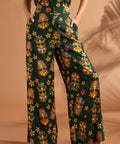 Woman wearing black tropical tiki print wide leg pants with side pockets.