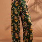 Full-length view of black tropical floral and tiki print pants with high-rise waist.