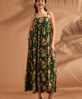 Woman wearing tropical tiki print maxi dress with hidden side pockets and relaxed silhouette.