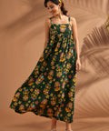 Woman wearing colorful tropical novelty print maxi dress with flowing skirt.