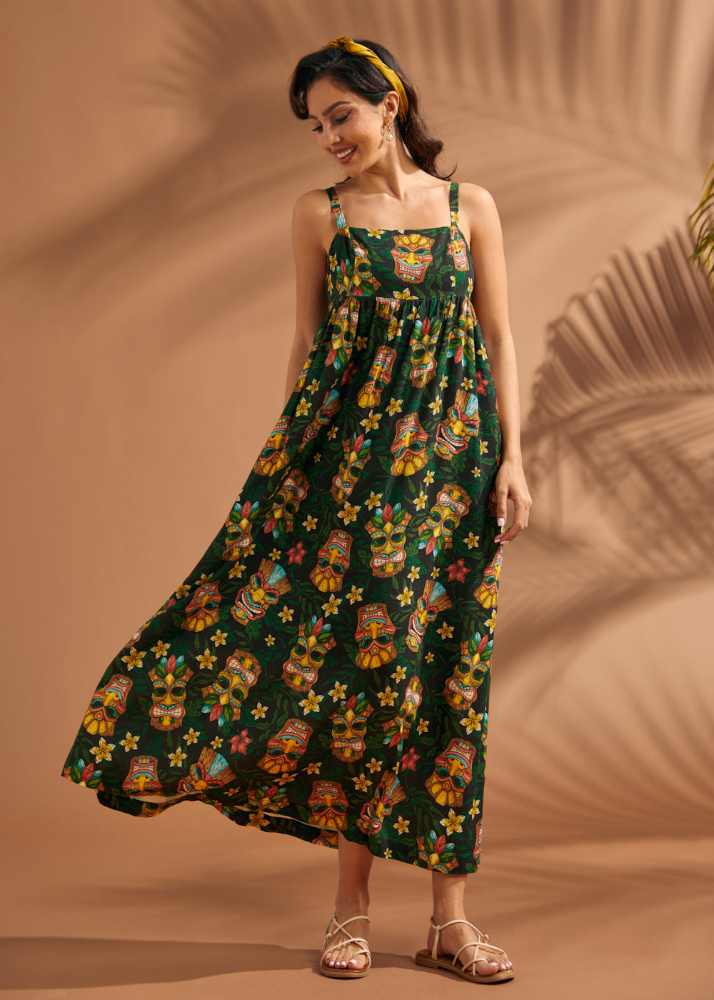 Woman wearing colorful tropical novelty print maxi dress with flowing skirt.
