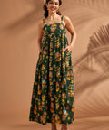 Woman wearing tropical tiki print maxi dress with square neckline and adjustable straps.