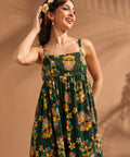 Woman wearing vintage-inspired tiki print maxi dress with tropical floral motif.
