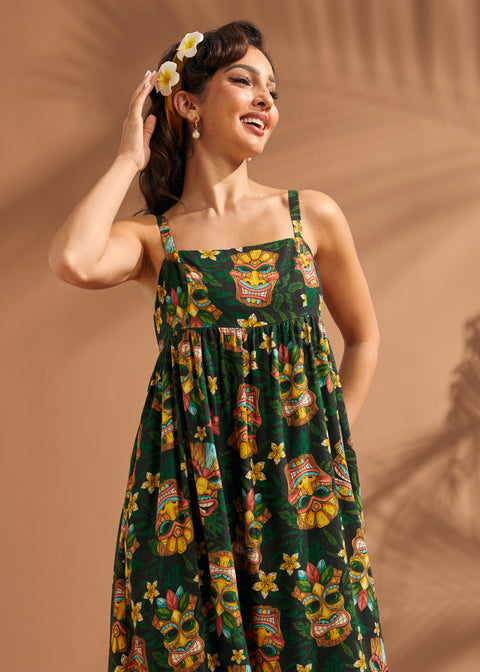 Woman wearing vintage-inspired tiki print maxi dress with tropical floral motif.