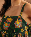 Detail of square neckline and tiki mask novelty print on maxi dress.