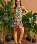 Woman modeling a sleeveless swing mini dress with stylized leopard print and tropical foliage.
