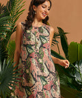 Woman wearing a sleeveless A-line mini dress with retro jungle print and decorative front buttons.