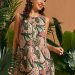 Woman wearing a sleeveless A-line mini dress with retro jungle print and decorative front buttons.