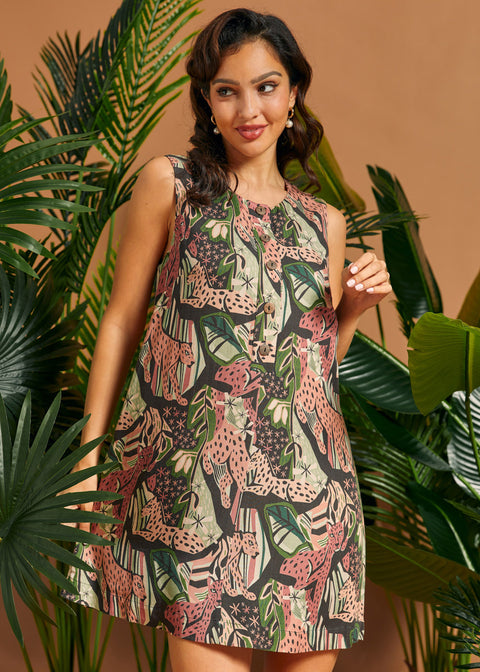 Woman posing in a sleeveless tropical print mini dress with relaxed A-line silhouette.