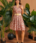 Front view of vintage-inspired cap sleeve button front dress with woven belt.