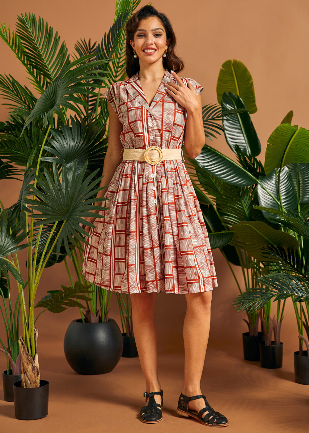 Front view of vintage-inspired cap sleeve button front dress with woven belt.