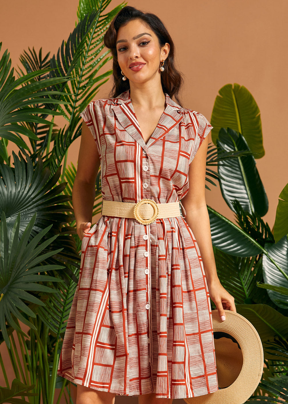 Woman wearing terracotta geometric print midi-inspired shirt dress with pockets.