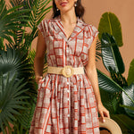 Woman wearing terracotta geometric print midi-inspired shirt dress with pockets.