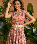 Woman wearing vintage-inspired fit-and-flare dress with removable woven belt.