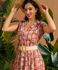 Woman wearing terracotta geometric print button front shirt dress with woven belt.